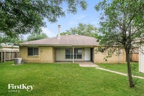 Katy house for rent - a small brick house with a lawn and trees