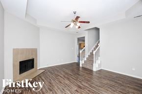 Fort Worth house for rent - a living room with a fireplace and a ceiling fan