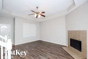 Fort Worth house for rent - a living room with a fireplace and a ceiling fan