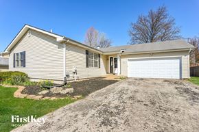 Florissant house for rent - a home with a gravel driveway and a white garage door