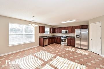 Douglasville house for rent - a kitchen with wooden cabinets and a stainless steel refrigerator