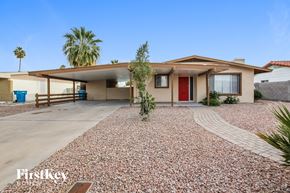 Phoenix house for rent - a house with a red door and a gravel driveway