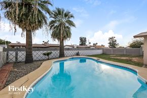 Phoenix house for rent - a large pool in a backyard with palm trees