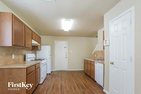 Houston house for rent - a kitchen with wood flooring and white appliances and wooden cabinets