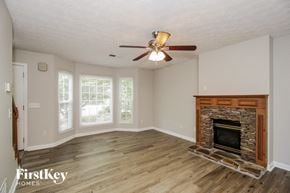 Acworth house for rent - a living room with a fireplace and a ceiling fan