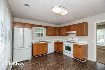 Acworth house for rent - a kitchen with white appliances and wooden cabinets
