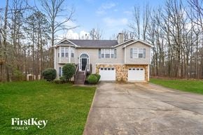 Douglasville house for rent - a white house with a driveway and a white garage door