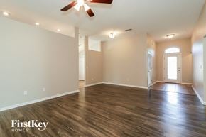 Middleburg house for rent - A spacious room with wooden floors and a ceiling fan.