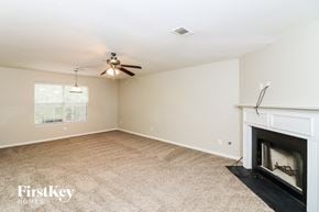 Powder Springs house for rent - a living room with a fireplace and a ceiling fan