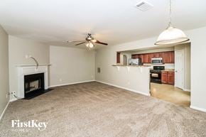 Powder Springs house for rent - an empty living room with a fireplace and a ceiling fan
