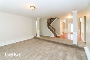 Powder Springs house for rent - a living room with a carpeted floor and a staircase