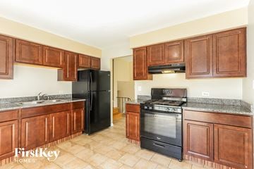 Matteson house for rent - A kitchen with wooden cabinets and black appliances.