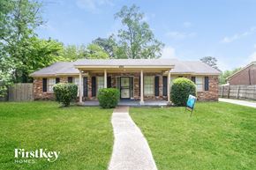 Memphis house for rent - a small brick house with a lawn and a walkway to the front door