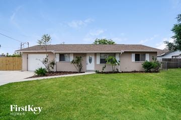 Lehigh Acres house for rent - a white house with a lawn and a driveway