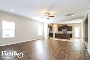 Pfafftown house for rent - A spacious living room with wood flooring and a ceiling fan.