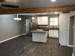 Phoenix house for rent - an open kitchen and living room with a wooden ceiling
