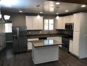 Phoenix house for rent - a large kitchen with white cabinets and stainless steel appliances