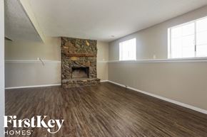 Memphis house for rent - A room with a stone fireplace and wooden flooring.