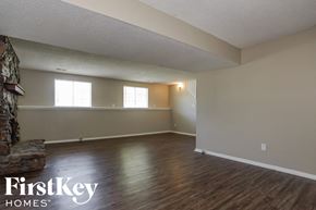 Memphis house for rent - A room with wooden floors and a stone fireplace.