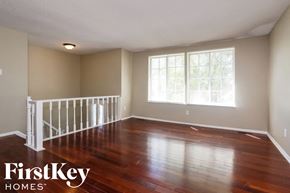 Memphis house for rent - Empty room with wooden floors and white railings.