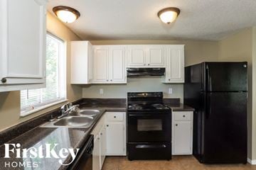 Memphis house for rent - A kitchen with black appliances and white cabinets.
