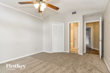 Plant City house for rent - a spacious living room with carpet and a ceiling fan