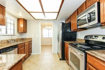 Phoenix house for rent - a kitchen with stainless steel appliances and granite counter tops