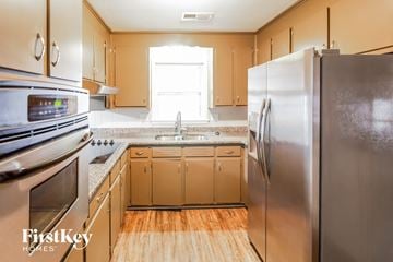 North Charleston house for rent - A kitchen with wooden cabinets and stainless steel appliances.