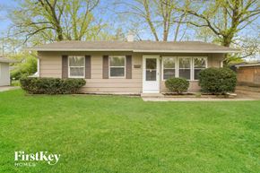 Indianapolis house for rent - a small tan house with a lawn and a white door