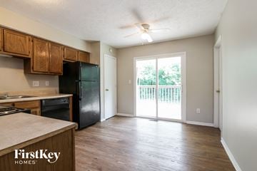 Indianapolis house for rent - A kitchen with wooden cabinets and a black fridge.