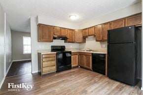 Indianapolis house for rent - A kitchen with wooden cabinets and black appliances.