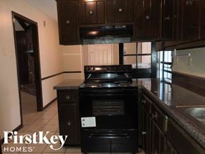 Memphis house for rent - a kitchen with black appliances and dark wood cabinets
