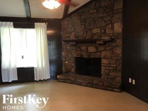 Memphis house for rent - a living room with a stone fireplace and a window