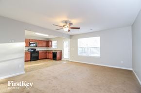 Winston-Salem house for rent - an empty living room and kitchen with a ceiling fan