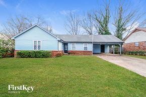 Memphis house for rent - A blue house with a white door and a brick wall.