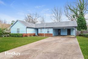 Memphis house for rent - A blue house with a grey roof and a concrete driveway.