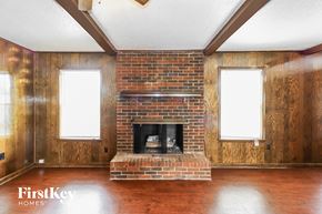 Memphis house for rent - A room with a brick fireplace and wooden floors.