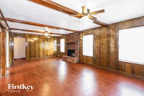 Memphis house for rent - A spacious room with wooden floors and a fireplace.