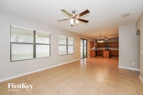 Melbourne house for rent - a spacious living room and kitchen with a ceiling fan