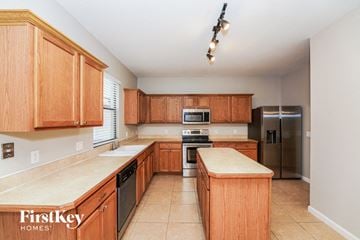 Melbourne house for rent - a large kitchen with wooden cabinets and stainless steel appliances