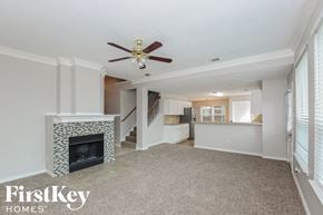Mckinney house for rent - a living room with a fireplace and a ceiling fan