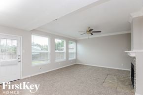 Mckinney house for rent - an empty living room with a ceiling fan and windows