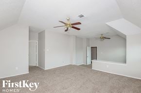 Mckinney house for rent - a bedroom with a ceiling fan and a carpeted floor