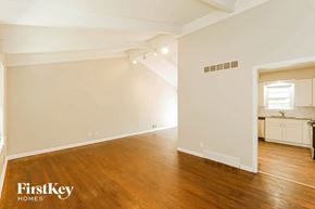 Kansas City house for rent - the living room and dining room with wood floors and white walls