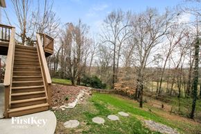 Winston-Salem house for rent - stairs to the deck of a cabin with trees and a river