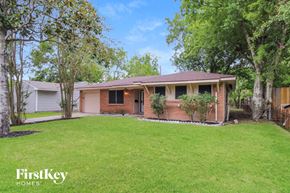 Houston house for rent - a small brick house with a lawn and trees