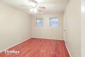 Houston house for rent - a spacious living room with wood flooring and a ceiling fan