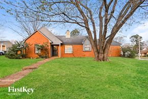 Memphis house for rent - a red brick house with a large tree in the yard