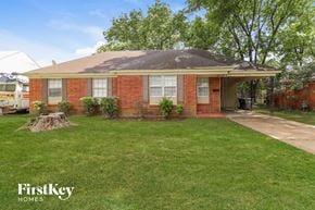 Memphis house for rent - a small brick house with a lawn and a tree stump in the front