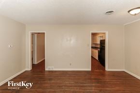 Memphis house for rent - an empty living room with wood flooring and a door to a kitchen
